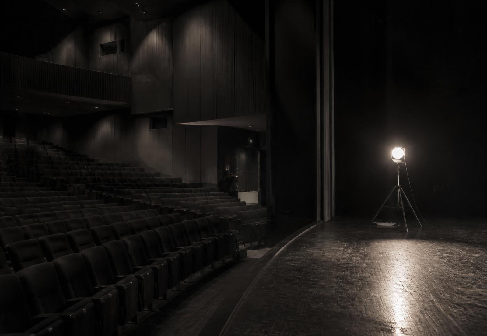 An empty private theatre lit by a single work light